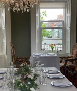 a dining room with a table with glasses and flowers at Charlemont House in Dungannon