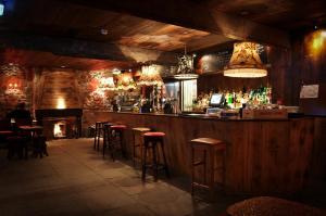 a bar with stools and a fireplace in a restaurant at The Garden Rooms at Newton Hall Estate in Chathill