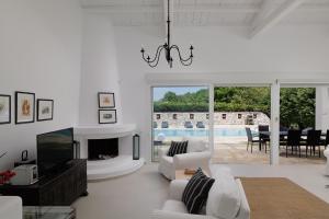 a living room with white furniture and a fireplace at Villa Levanda by WhiteDream Villas in Kassiopi