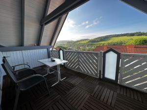 d'un balcon avec une table et des chaises et une vue. dans l'établissement Ferienwohnung zum Lösershag, à Wildflecken