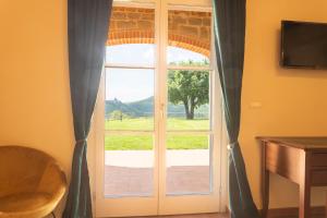 una puerta a una ventana con vistas a un campo en Casale la Querce by VacaVilla, en Civitella in Val di Chiana