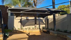 un patio con banco y sombrilla en One85 in Vinko, en Pretoria