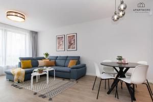 a living room with a blue couch and a table at City Center - Długa Grobla by Apartmore in Gdańsk