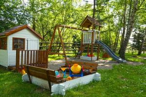 um parque infantil com escorrega e uma casa de brincar em Domki Nad Potokiem574067621 em Ustrzyki Dolne