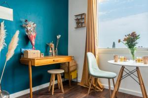 Cette chambre comprend un bureau, une table et des chaises. dans l'établissement Modern and colourful apartment with balcony - Montpellier - Welkeys, à Montpellier