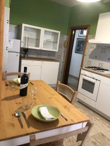 una cocina con una mesa de madera y una botella de vino en Casa elegante in centro a Paglieta, en Paglieta