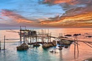 a dock in the water with a sunset at Casa elegante in centro a Paglieta in Paglieta