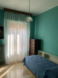 a bedroom with blue walls and a bed and a window at Casa elegante in centro a Paglieta in Paglieta