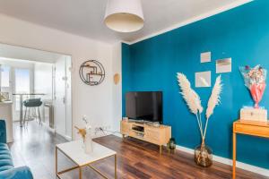 ein Wohnzimmer mit einer Wand mit blauen Akzenten in der Unterkunft Modern and colourful apartment with balcony - Montpellier - Welkeys in Montpellier