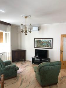 sala de estar con 2 sillas, sofá y TV en Casa elegante in centro a Paglieta, en Paglieta