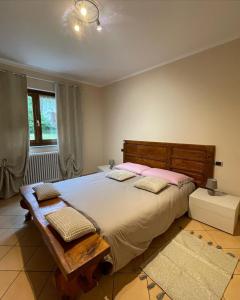 a bedroom with a large bed with pink pillows at Casa Iris in Omegna
