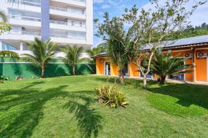 a yard with palm trees and a building at Pousada Villa Piemonte in Ubatuba