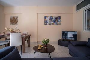 a living room with a couch and a tv at Thetis Luxury Apartment in Samos