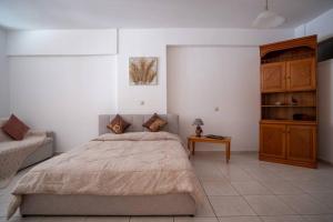 Schlafzimmer mit einem Bett und einem Holzschrank in der Unterkunft Thetis Luxury Apartment in Samos