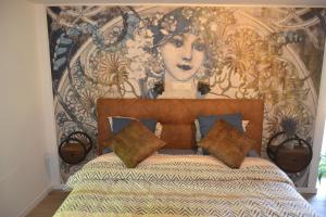 a bedroom with a bed with a painting on the wall at La Jo Welcome Home in Theux