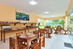 Un restaurante con mesas y sillas de madera y un mostrador. en Pousada Villa Piemonte, en Ubatuba
