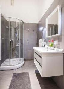 a bathroom with a shower and a sink and a tub at Elegant Apartment in Super Central Location in Budapest