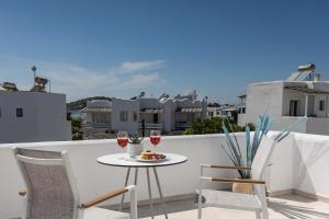 - une table avec deux verres de vin sur le balcon dans l'établissement Naxos Leisure, à Ágios Prokópios