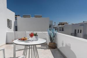 - une table avec un verre de vin sur le balcon dans l'établissement Naxos Leisure, à Ágios Prokópios