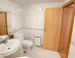 een badkamer met een wit toilet en een wastafel bij El rincón del 12 in Pontevedra