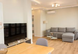 un soggiorno con divano e TV a schermo piatto di Seaview Haven - Elegant 2BD Flat in Balchik by Flat Mаnager a Balchik