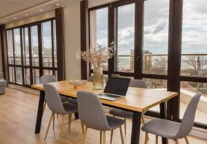 una sala da pranzo con tavolo e computer portatile di Seaview Haven - Elegant 2BD Flat in Balchik by Flat Mаnager a Balchik