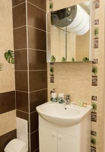 un bagno con lavandino, WC e specchio di Seaview Haven - Elegant 2BD Flat in Balchik by Flat Mаnager a Balchik