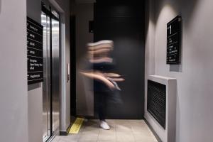 a woman is walking through a door in a building at Sapiens Hotel in Tashkent +47 photos
