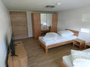 a small room with two beds and a television at Da Camillo in Oberstaufen