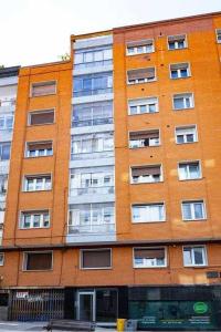 a tall brick building with windows on the side of it at La Capilla Apartamento in Oviedo