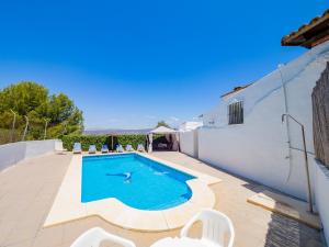 ein Swimmingpool mit weißen Stühlen und einem weißen Haus in der Unterkunft Cubo's Cortijo La Palmera in Cártama