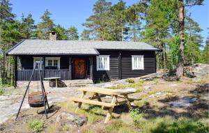 a picnic table in front of a small cabin at 3 Bedroom Lake Front Home In Sperrebotn in Sperrebotn