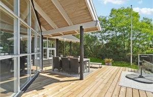 a patio with a table and chairs on a wooden deck at Holiday Home Klitvej Ebeltoft X in Ebeltoft