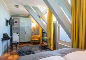 a bedroom with yellow curtains and a bed and a window at The New Yorker Hotel Köln-Messe in Cologne