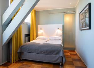 een slaapkamer met een bed met gele gordijnen bij The New Yorker Hotel Köln-Messe in Keulen