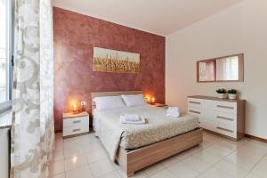 a bedroom with a bed and a red wall at Casa Terrazzo - Centro Città e UniBG in Bergamo