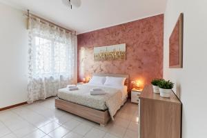 a bedroom with a bed and a pink wall at Casa Terrazzo - Centro Città e UniBG in Bergamo