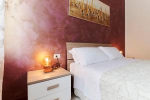 a bedroom with a bed and a night stand with a lamp at Casa Terrazzo - Centro Città e UniBG in Bergamo