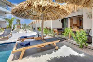 a patio with an umbrella and a pool at Belnem House Bonaire in Kralendijk