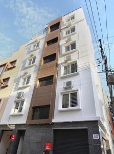 um edifício branco alto com janelas numa rua em Hotel Royal Residence HSR Layout em Bangalore