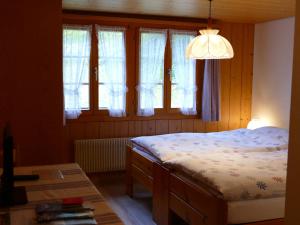 a bedroom with a bed and some windows at Landgasthof Tännler in Innertkirchen