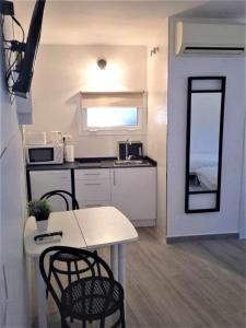 a small kitchen with a table and chairs and a mirror at Moderno apartamento en el corazón de Madrid Sol in Madrid