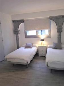 a bedroom with two twin beds and a window at Moderno apartamento en el corazón de Madrid Sol in Madrid