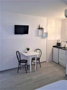 a white table and two chairs in a kitchen at Moderno apartamento en el corazón de Madrid Sol in Madrid