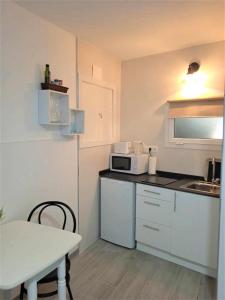 a small kitchen with a table and a microwave at Moderno apartamento en el corazón de Madrid Sol in Madrid