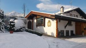 une maison avec de la neige devant elle dans l'établissement Haus Silbertann, à Schönau am Königssee