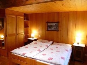 a bedroom with a bed with pink flowers on it at Landgasthof Tännler in Innertkirchen