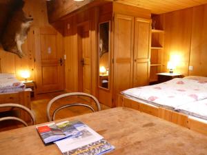 a room with two beds and a table and chairs at Landgasthof Tännler in Innertkirchen