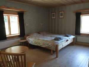 1 dormitorio con 1 cama, mesa y sillas en Kramer Stugan, en Vikarbyn