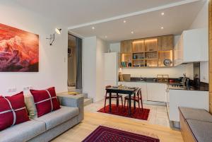 a living room with a couch and a kitchen at Apartment Chéserys, Alpes Travel, Les Praz Sleeps 2-4 in Chamonix-Mont-Blanc